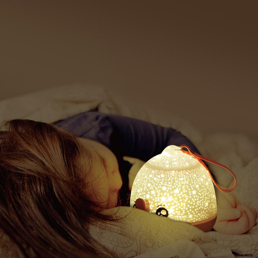 Warm Lucky Fish LED night light beside a resting person, projecting a starry ambiance.